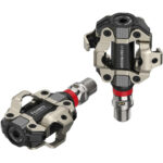 Two silver, black and red Favero Assioma PRO MX-2 MTB Power Meter Pedals with one standing up and one laying down against a white background.