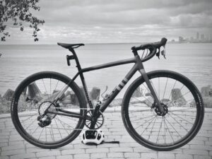 A black and white photo of a gravel bike with a Garbaruk cassette next to the water.