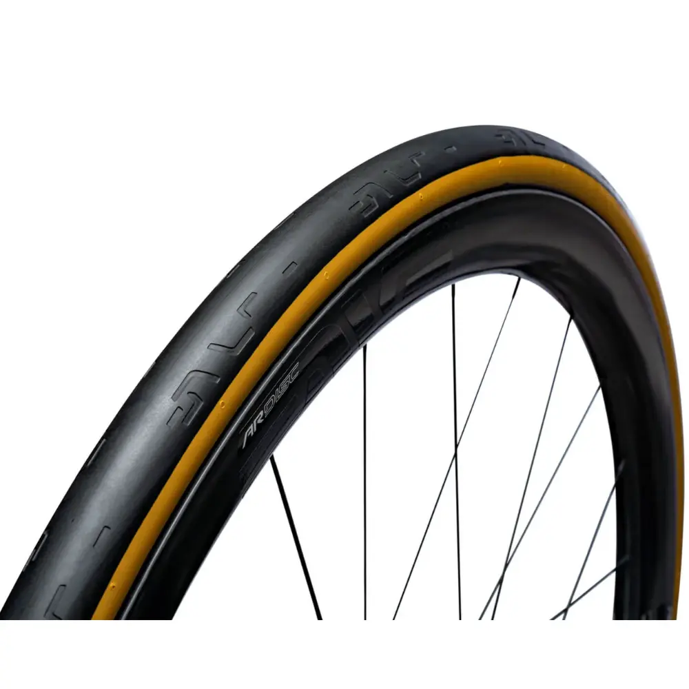 A close up of a black ENVE SES Tubeless Road Tire with a tan wall.