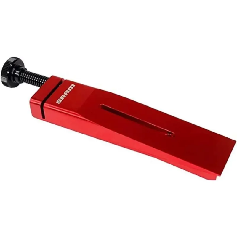 A glossy red SRAM Ultimate Piston Press with black screw for adjustment.