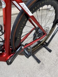 A Favero Assioma PRO RS-2 pedal mounted on a red road bike.