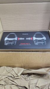A set of Assioma PRO RS-2 Power Meter Pedals in their retail packaging.