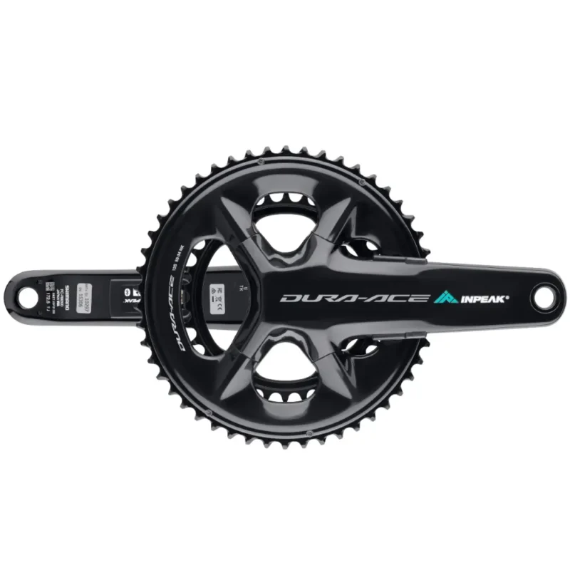 A black Shimano Dura Ace R9200 crankset featuring INPEAK-POWERCRANK-E-TWiN2 sensors installed, with a teal and white INPEAK decal on the drive side crank arm.