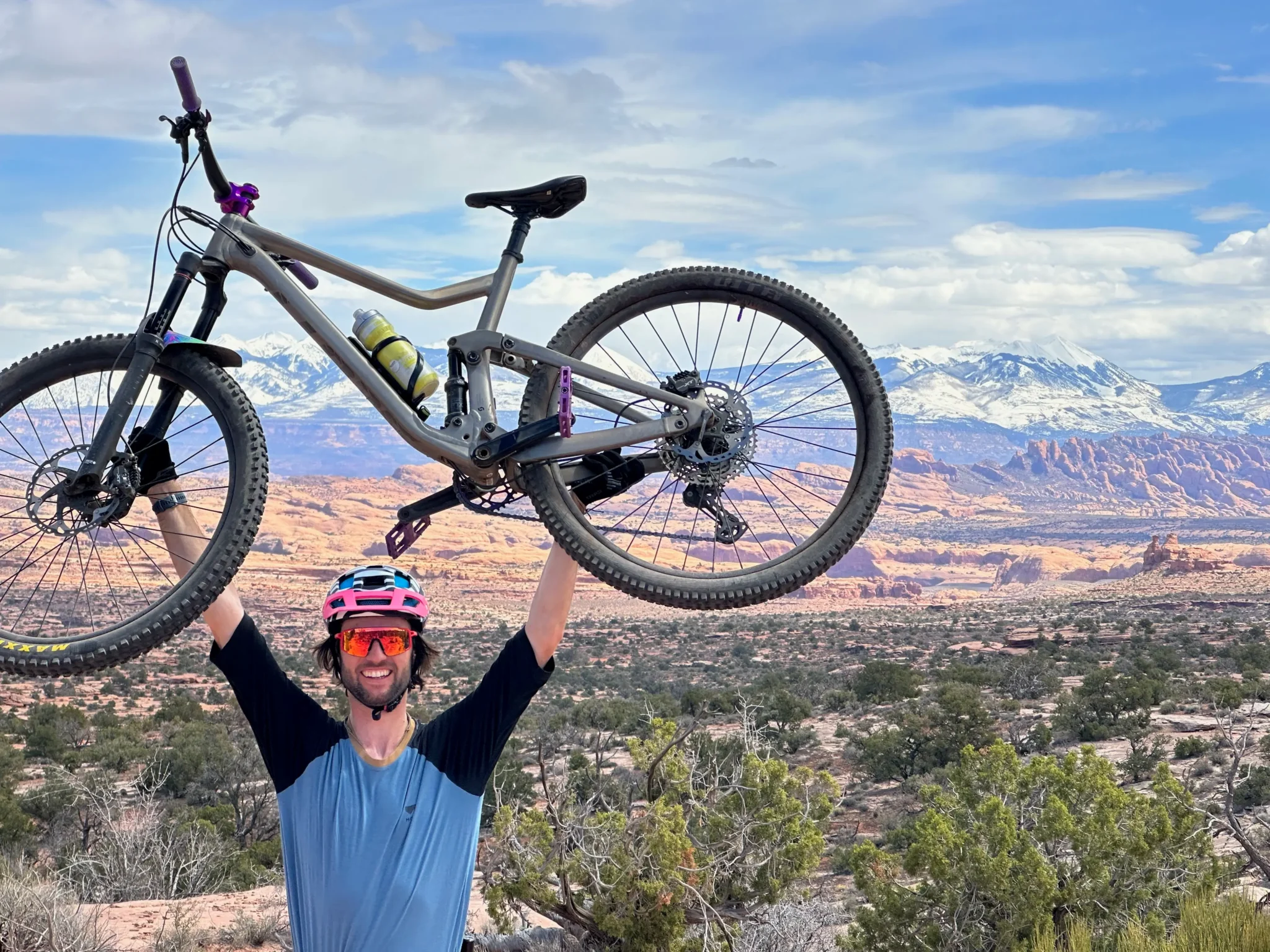 Eugene Cech holding his MTB above his head in Moab.