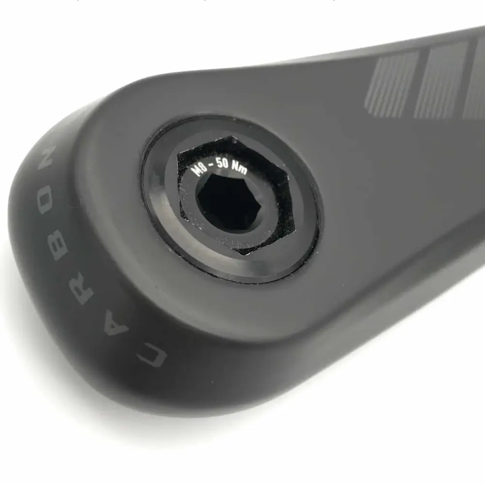 A black Praxis M24 Crank Bolt and Self-Extracting Cap installed on a black praxis crank arm