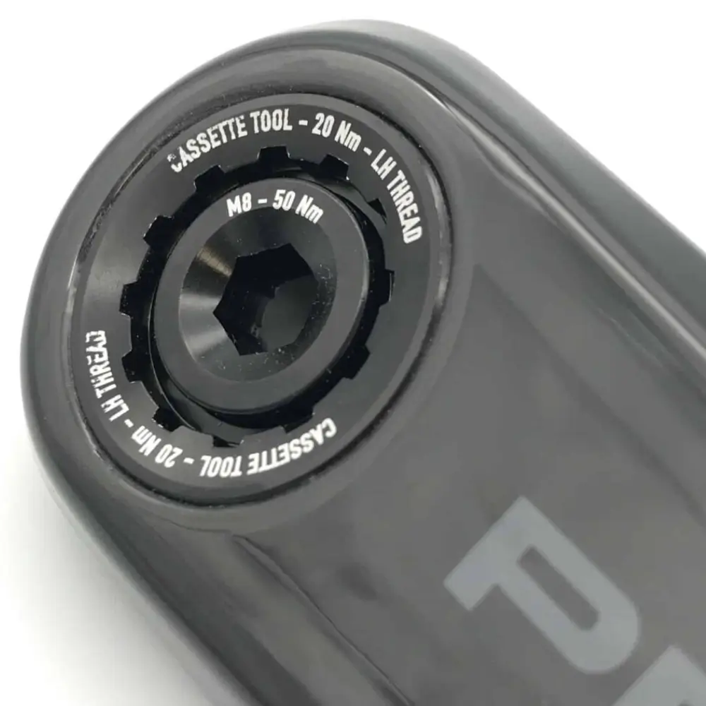 A black Praxis M30 Crank Bolt and Self-Extracting Cap installed on a black Praxis crank arm