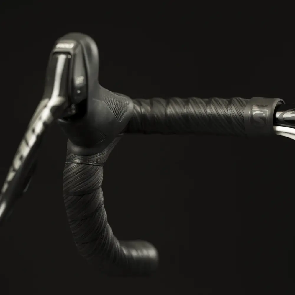 Black Silca Nastro Cuscino Bar Tape installed on a handlebar with a black background