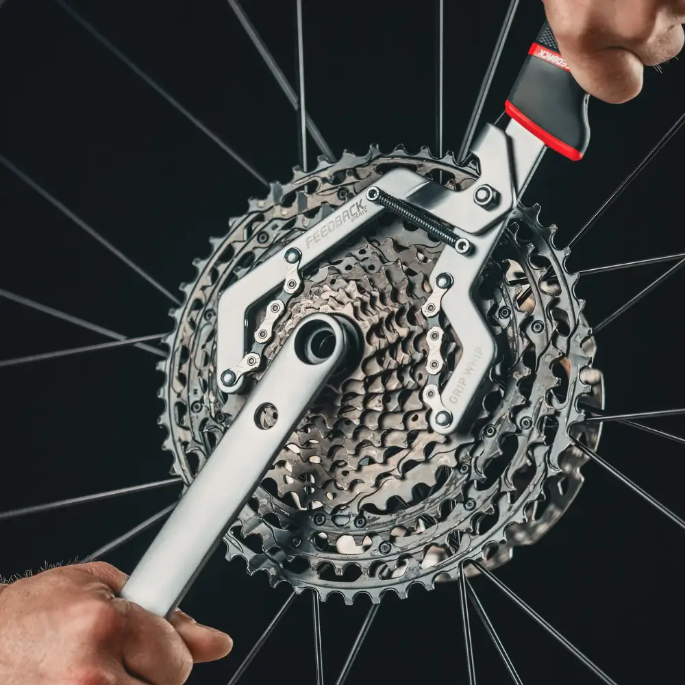 A Feedback Sports Grip Whip Cassette Tool being shown removing a wide range Shimano cassette in conjunction with a cassette lockring tool