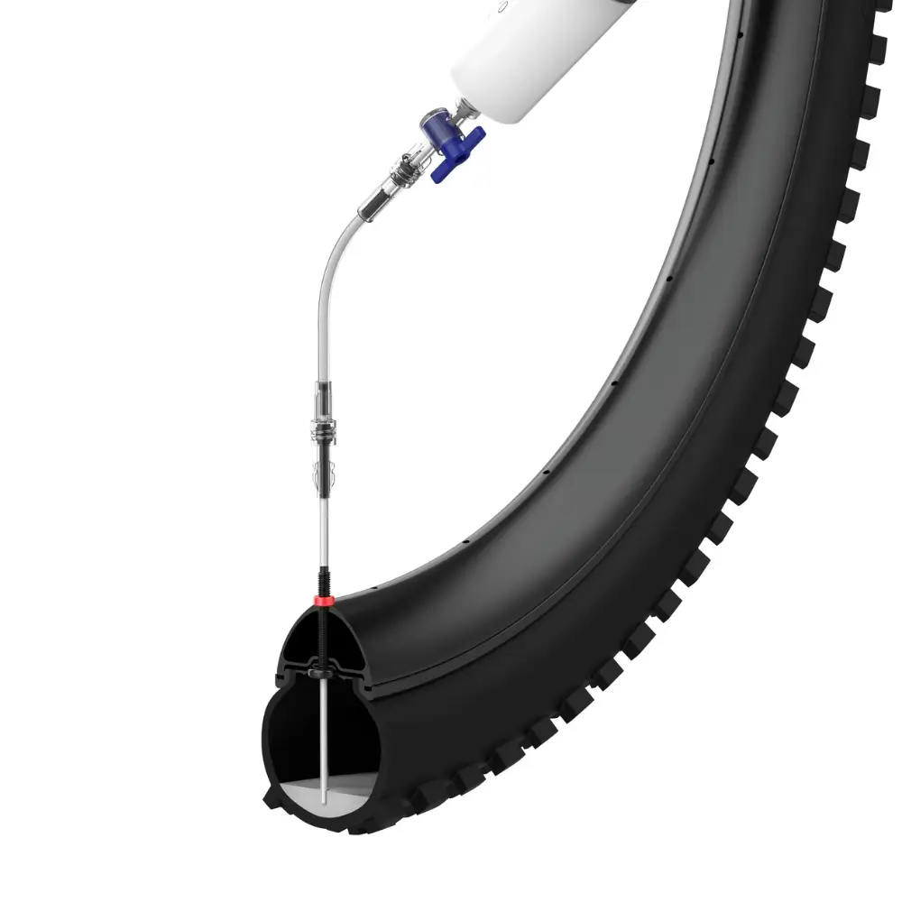 An image of the KOM Cycling Tubeless Sealant Injector in use with a tire cutaway